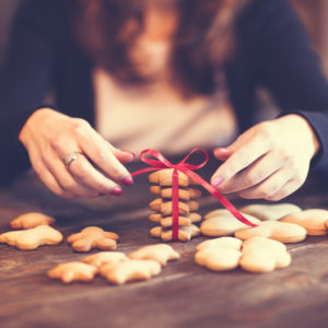 Close up image of a woman baking and decorating cookies